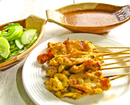Satay ,grilled tumeric pork with sauce and cucumber saladの写真素材
