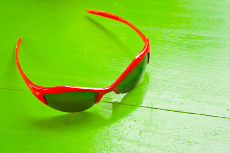 red sunglasses on green table 
