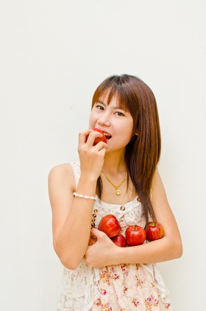 asain girl eating apple on white background の写真素材