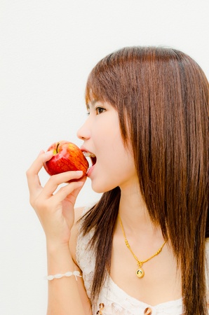smile asian girl eating apple on white background の写真素材
