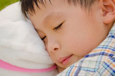 asain boy sleeping in the gardenの写真素材