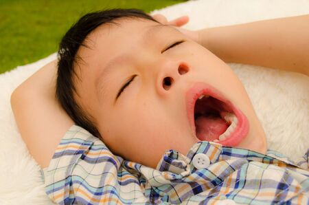 asain boy sleeping in the gardenの写真素材