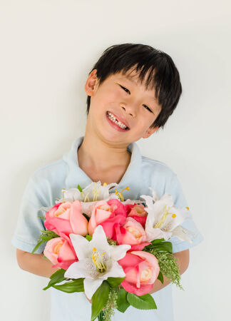 Asian boy holding flower bouquet on white backgroundの写真素材