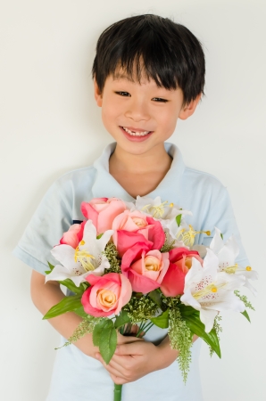 Asian boy holding flower bouquet on white backgroundの写真素材