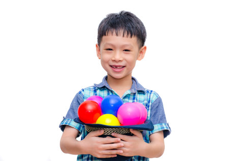Asian boy holding colorful balls on white background