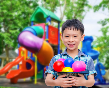 Asian boy smiling at colorful playground の写真素材