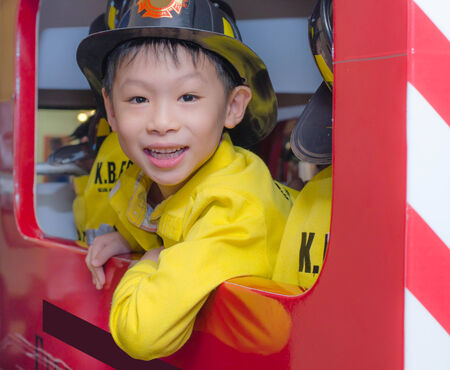 little Asian boy in firefighter uniform の写真素材