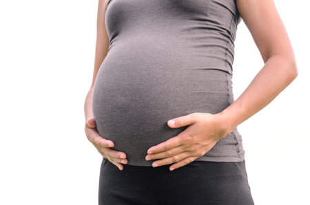 Close up of Asian pregnant woman tummy over white background