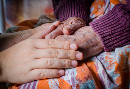 Young girl hand touch her grandma handの写真素材