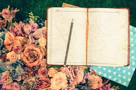 Note book and flower bouquet with vintage filterの写真素材