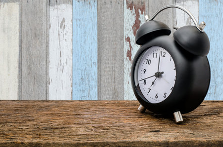 Clock on wood table over old wood wall
