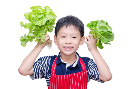 Asian boy with fresh vegetable on white backgroundの写真素材
