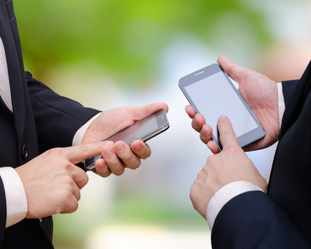 Two business man hand using smart phoneの写真素材