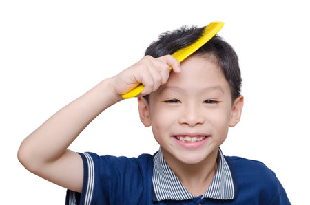 Asian boy smiling with yellow comb on his hairの写真素材