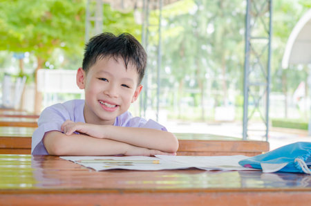 Asian schoolboy in uniform doing homework at school