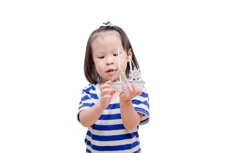 Little asian girl with boat toy over whiteの写真素材