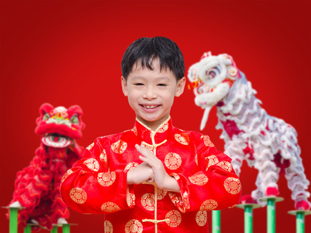 Asian boy in chinese traditional dress holding red packet moneyの写真素材