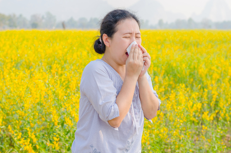 Asian woman has allergy at flower fieldの写真素材