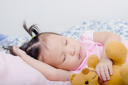 Little Asian girl sleeping on bedの写真素材