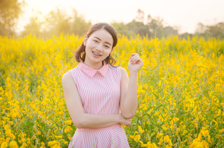 Young asian girl smiles in flower fieldの写真素材