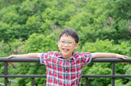 Young asian boy smiling in parkの写真素材