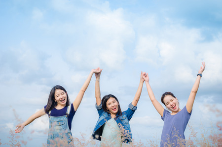 Three happy asian girls in grass field with vintage filterの写真素材