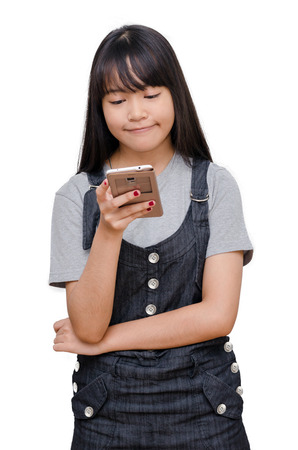 Young asian girl typing message on cellphone over whiteの写真素材