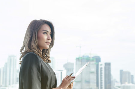 Asian businesswoman holding tablet computer and smile