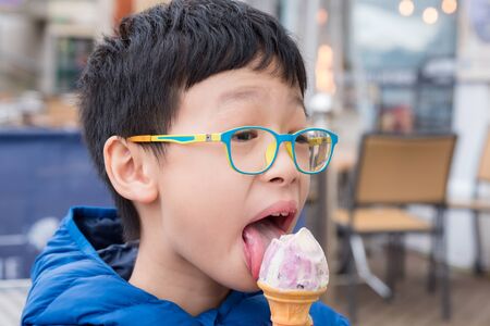 Young asian boy eating ice creamの写真素材