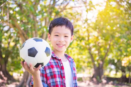 boy holding soccer ball in parkの写真素材
