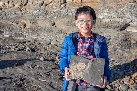 Boy holding stone with fossilの写真素材