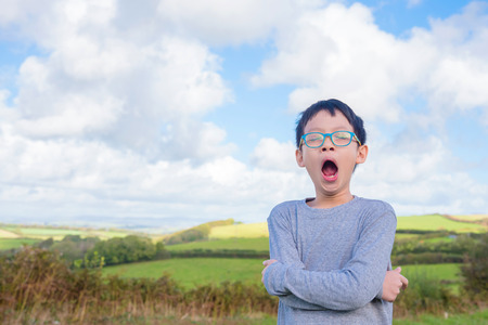 Boy yawning in fieldの写真素材