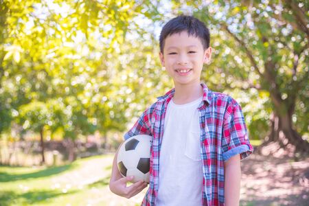 Boy holding ball in parkの写真素材