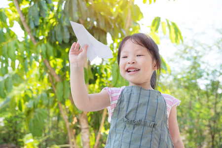 Little asian girl playing paper planeの写真素材
