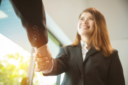asian businesswoman shaking hand with partnerの写真素材