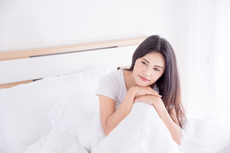 Beautiful woman relaxing in bedroomの写真素材