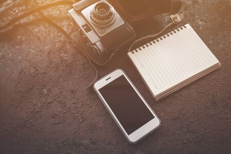 mobile phone ,notebook and camera on tableの写真素材