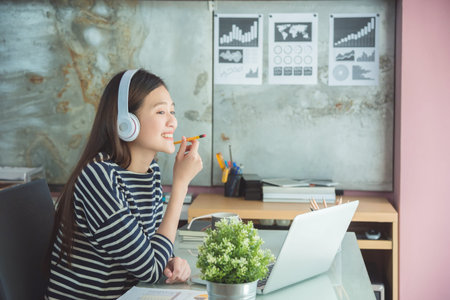 Beautiful woman listen music in officeの写真素材