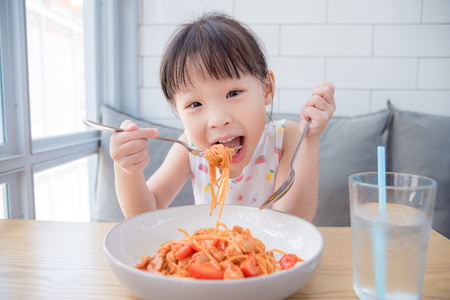 Little asian girl eating spagethettiの写真素材