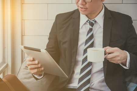 businessman reading news from tablet computerの写真素材
