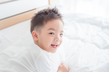 Happy boy on bedの写真素材