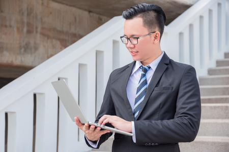 Young businessman using laptop computer outdoorの写真素材