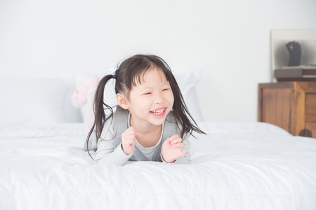 Little girl smiling on bedの写真素材