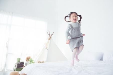 Little girl jumping on bedの写真素材
