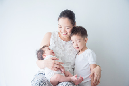 Asian mother smiles while holding her little child and hug her sonの写真素材
