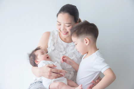 Asian mother smiles while holding her little child and hug her sonの写真素材