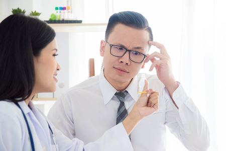 Asian female doctor demonstrates using condom method to a manの写真素材