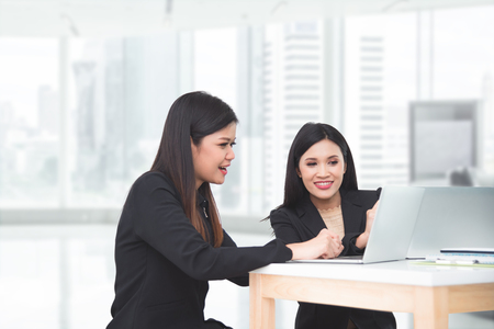 Two asian businesswoman discussing about work and smile in officeの写真素材