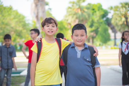 Young asian boys friend standing in park and smiling at cameraの写真素材