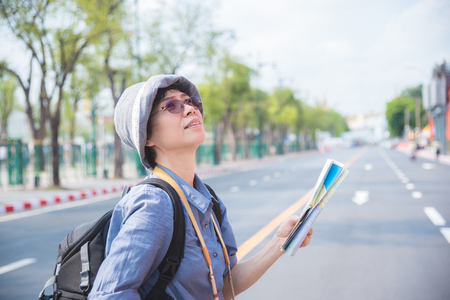 Senior asian woman tourist holding a paper map traveling in Bangkok,Thailand.の写真素材